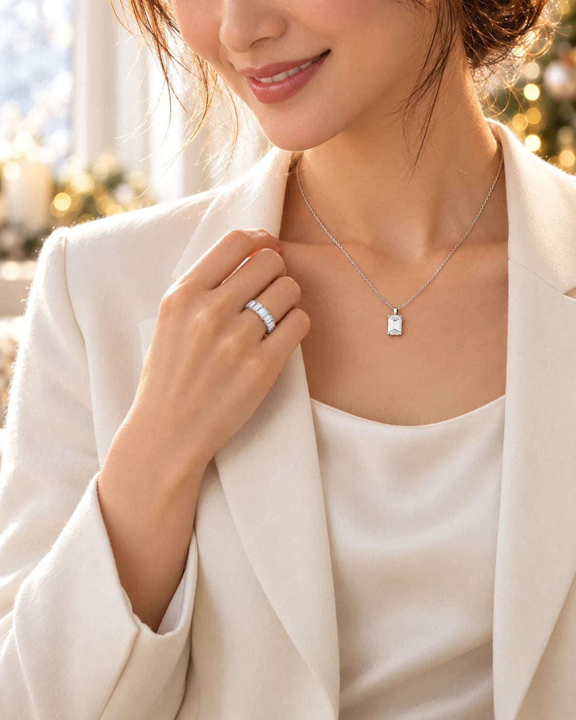 エメラルドカットのネックレスとエタニティリングを身につけて微笑む女性